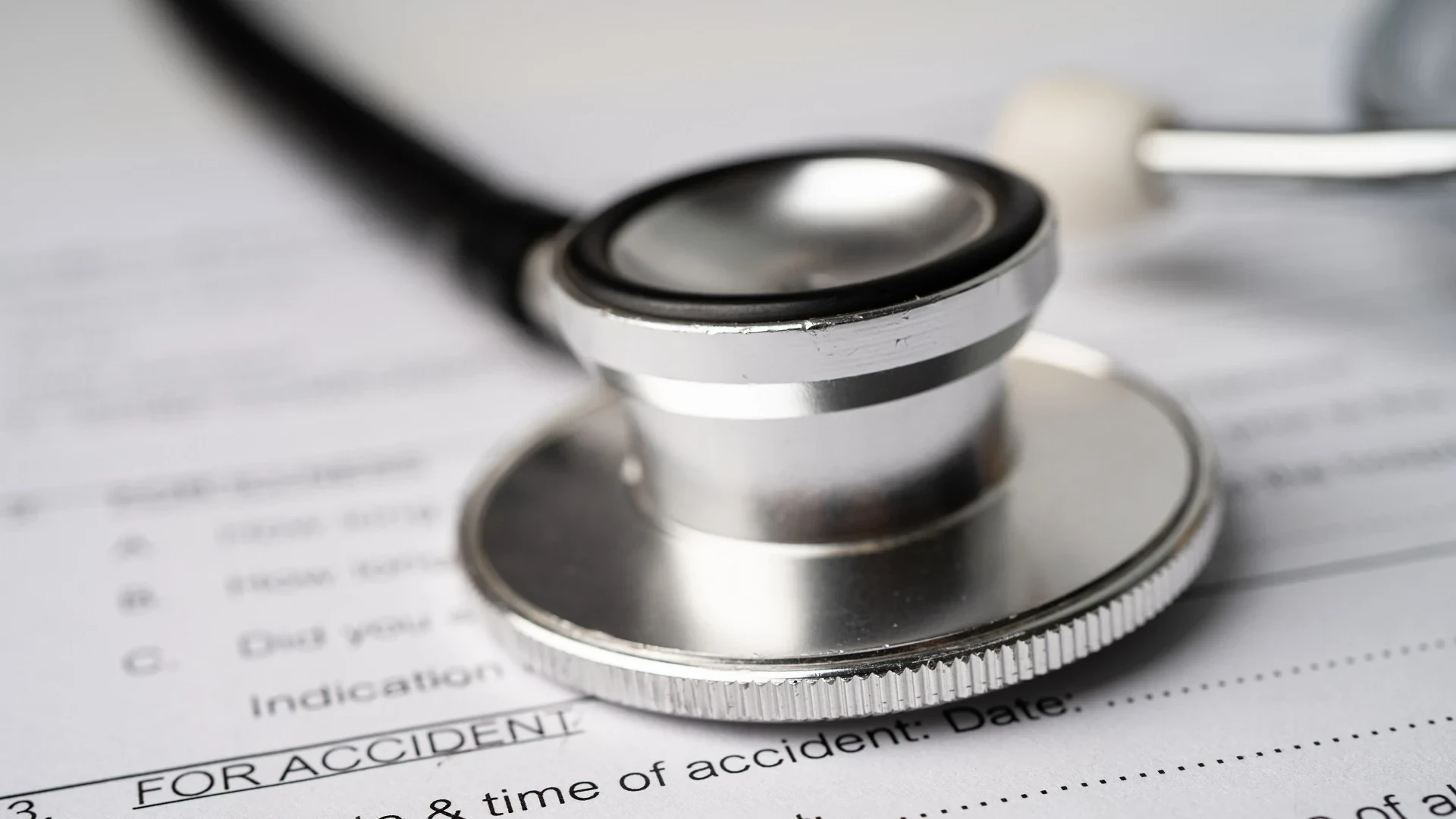 Closeup shot of a stethoscope on top of a personal injury claim form.