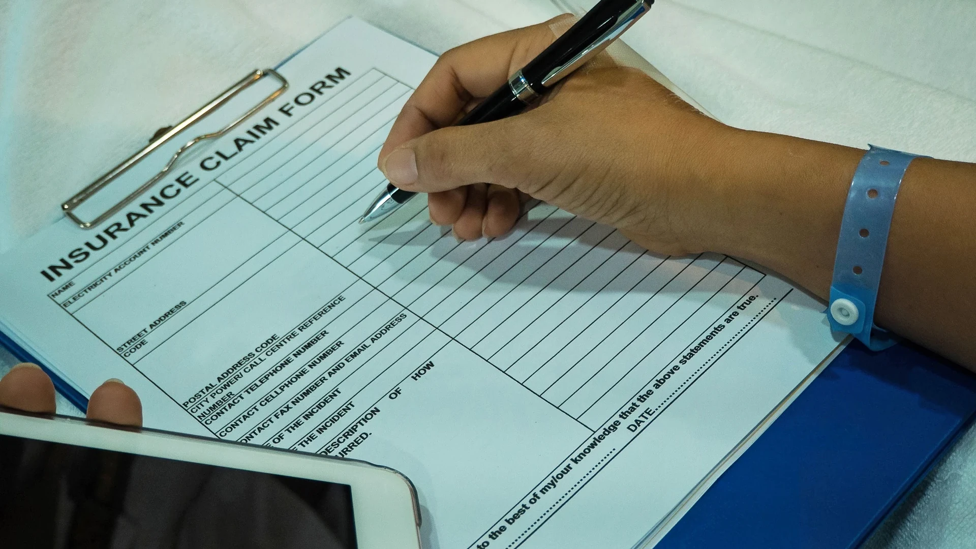 Individual filling out a car insurance claim form.